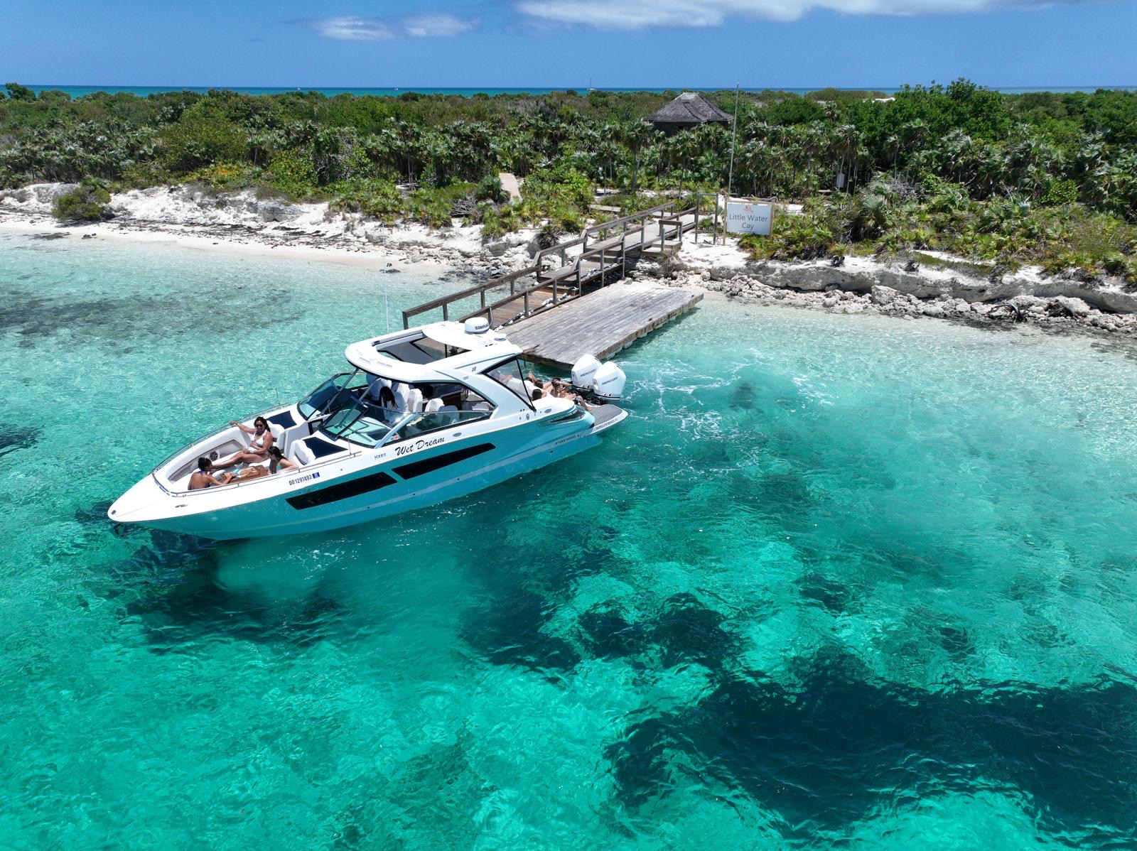 Blue motor yacht moored beside a dock at Little Water Cay