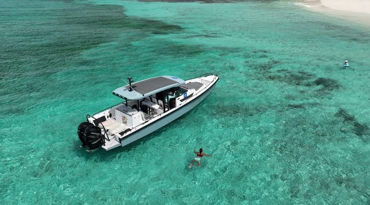 Grey Axopar tender at anchor over a shallow reef